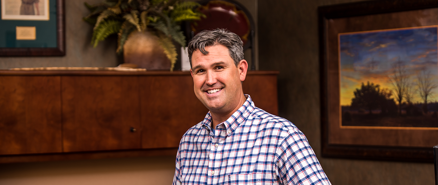 image of mortgage loan officer smiling and sitting on desk