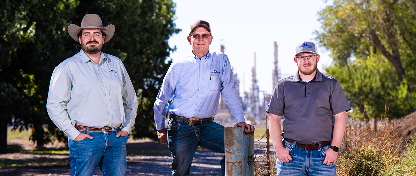image of three bankers in Artesia, NM in front of oil refinery