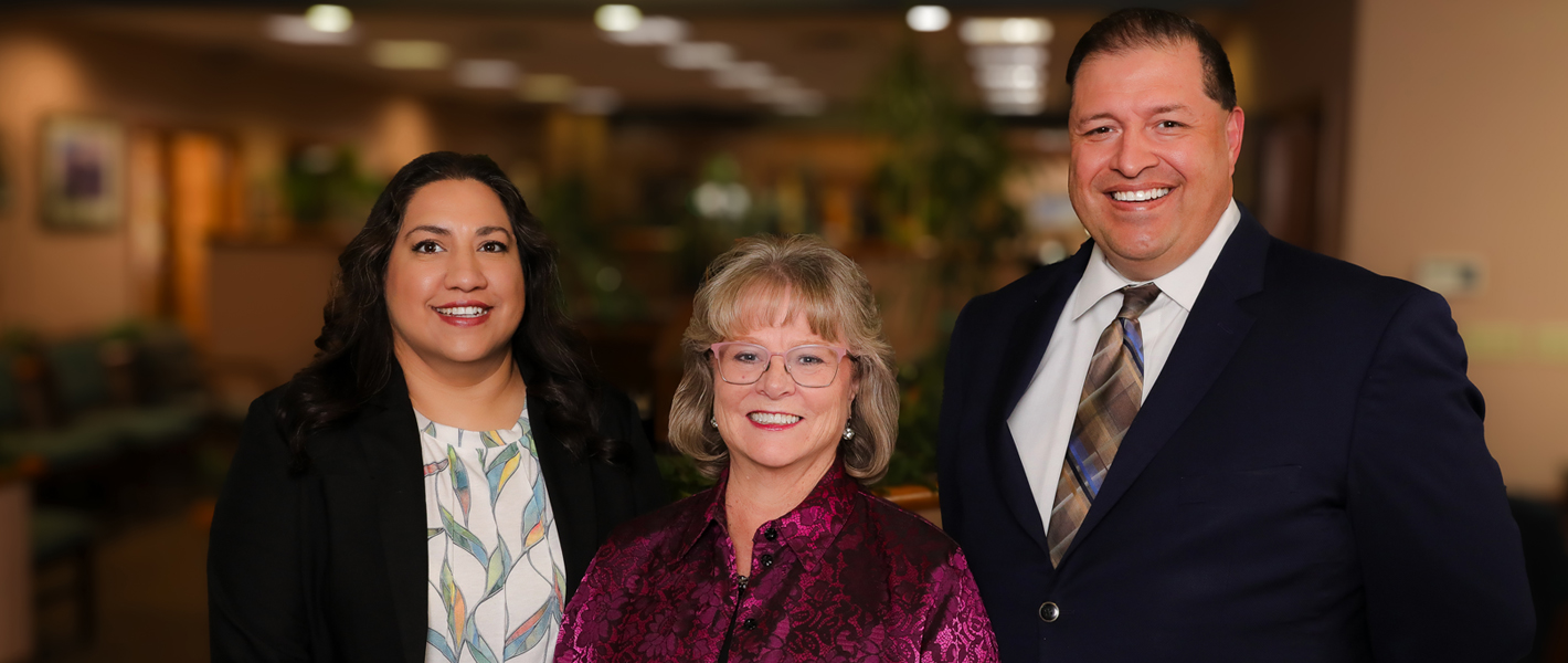 three bankers smiling inside a bank
